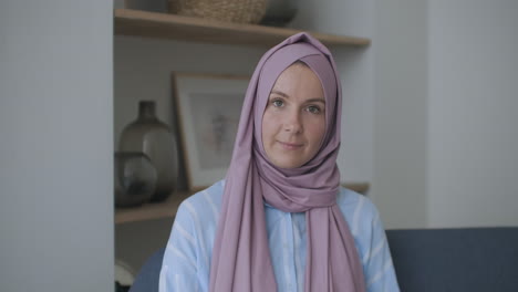 In-Die-Kamera-Schauend-Und-Mit-Dem-Kopf-Nickend,-Spricht-Eine-Muslimische-Frau-Im-Hijab-über-Eine-Videoübertragung-Und-Hört-Sich-Einen-Vortrag-An.-Remote-Videogespräch